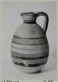 White Painted IV jug with a single loop handle and dark horizontal bands on a pale body