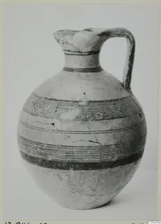 Jug with a trefoil mouth, a strap handle and horizontal bands of painted lines on a round body.