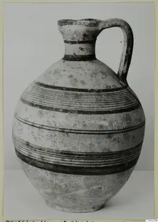 White Painted IV jug with a single loop handle and bands of dark painted lines around its body.