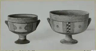 Two painted pottery footed bowls with side handles, shown side by side against a plain background.
