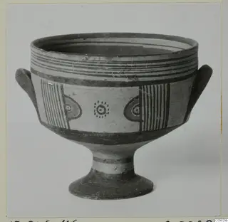 Footed bowl with two small handles and painted bands, with stripe and eye-like motifs on the body.