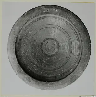 Shallow bowl seen from above, with concentric dark painted bands and a small central ring motif