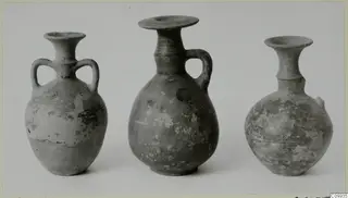 Three pottery vessels with flared rims, the left one with two handles, photographed side by side on a plain background