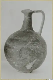 Pottery jug with a tall neck, a single loop handle and concentric circle motifs on the body