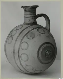 Globular jug with a short neck, single strap handle and dark painted concentric circles and bands on a pale surface
