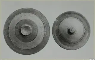 Two bowls seen from above, one larger, both with concentric grooves and a central knob.