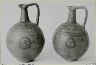 Two painted jugs with single loop handles, decorated with concentric circles and horizontal bands
