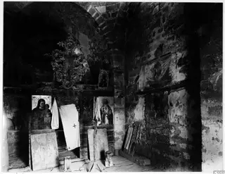 Interior of the Fokas chapel at Dali, with brick arches, painted icons and an ornate cross above them.
