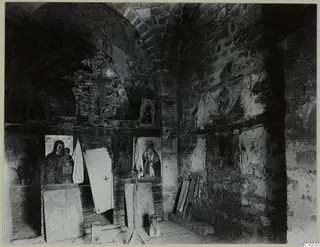 Interior of the Fokas chapel at Dali monastery, with painted icons on a wooden screen and a carved cross above