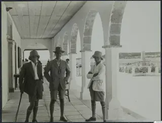 Westholm, Gjerstad and Sjöqvist standing under the arches of a white arcaded walkway