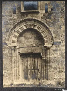 Doorway in a stone facade at Famagusta, with a moulded arch, paired columns and a wooden plank door