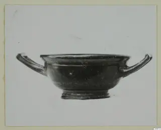 Black-glazed pottery bowl with two horizontal handles, shown against a plain background