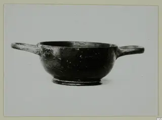 Black-glazed two-handled bowl with a low foot, seen from the side