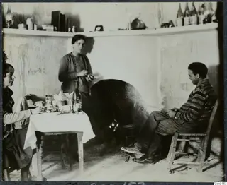 Rosa Lindros, an unknown woman and Erik Sjöqvist in a whitewashed room with a table of cups and bottles