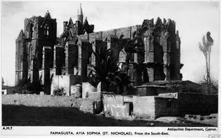 Ruined church of Ayia Sophia (St. Nicholas) at Famagusta, seen from the south-east, with palm trees and low walls in front