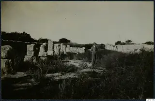 Standing man in suit and hat among low stone walls and scattered blocks at Salamis, Famagusta.