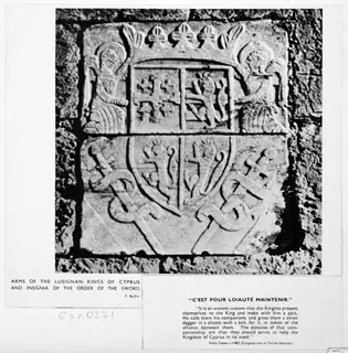 Carved stone arms of the Lusignan kings of Cyprus with crown, shield and swords, set in a stone wall