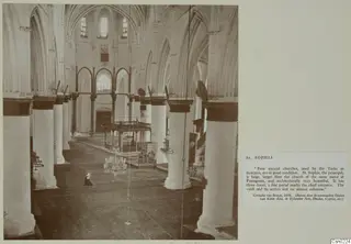 Interior of St. Sophia with rows of tall columns and pointed arches, a wooden platform and a chandelier, mounted on a card