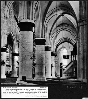 Interior of Ayia Sophia church in Nicosia, with tall pillars, ribbed vaults and a wooden pulpit on the right.