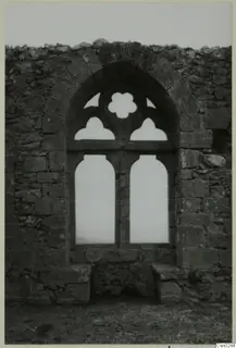 Ruined stone wall with an arched window opening, its upper part with a quatrefoil and cusped openings, in the Kyrenia Mountains