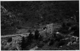 Ruined stone tower and walls among pine trees on a hillside in the Kyrenia Mountains