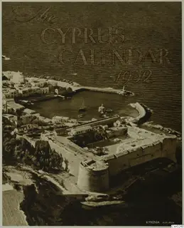 Aerial view of Kyrenia harbour and its walled castle, with a small boat, houses along the shore and the sea beyond