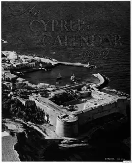 Aerial view of the Kyrenia harbour and castle, with a small boat in the harbour and houses along the shore