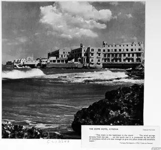 Seafront of the Dome Hotel, Kyrenia, with waves breaking over rocks below a long white hotel building