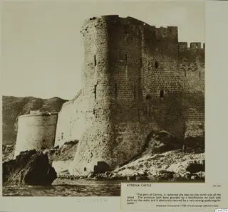 Kyrenia Castle seen from the sea, with a tall round tower and crenellated walls rising above rocks