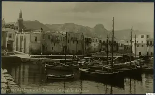 Kyrenia harbour with moored boats, waterfront buildings and rocky mountains behind