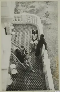Hotel terrace in Kyrenia with members of the Swedish excavation relaxing on deckchairs above a tiled floor.