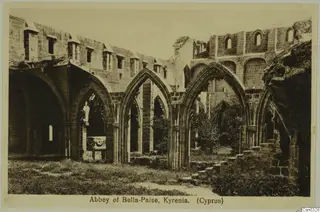 Abbey of Bella-Paise, Kyrenia: ruined stone arcade with pointed arches and walls, grass in the foreground.