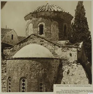 Byzantine chapel at St. Chrysostomos Monastery, with a tiled domed roof and a domed stone apse beside a tall cypress tree.
