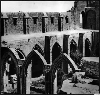 Ruined monastery building at Bellapais, with a row of pointed arches below a upper wall with small square openings