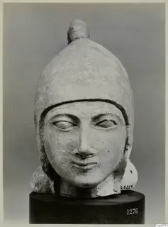 Limestone head with a helmet-like cap and knob on top, from the Cesn. Coll.