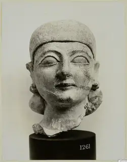 Limestone Neo-Cypriote head sculpture on a dark cylindrical stand