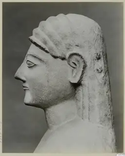 Carved limestone head and shoulder of a statue, shown in profile facing left