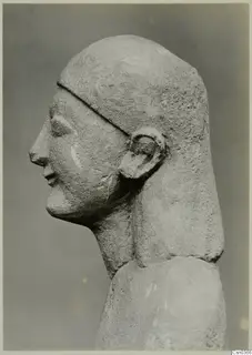 Limestone head and shoulders of a statue in profile, facing left.