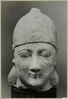 Limestone Neo-Cypriote head with a tall rounded cap, shown on a dark cylindrical stand