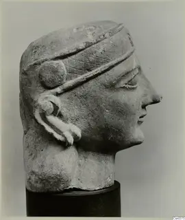 Limestone Neo-Cypriote head in right-facing profile with an incised diamond-patterned band and a spiral ear ornament