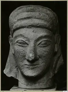Front view of a limestone sculpted head with a banded headdress, against a black background