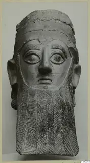Terracotta head of a bearded figure with large eyes and a chevron-patterned beard