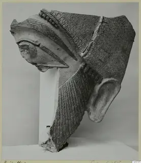 Terracotta Neo-Cypriote statue fragment with a large ear, a beak-like projection and stamped circle patterns.