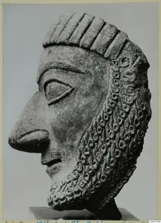 Terracotta head in profile from Dali, with a ringlet beard and grooved headdress