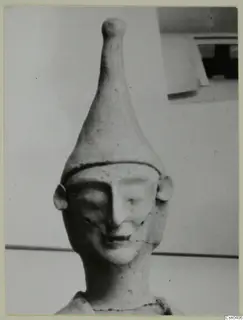 Terracotta figure head with a tall conical headdress and a smiling face, from Ayia Irini