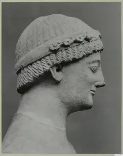 Limestone head in profile, facing right, with a patterned band across the hair
