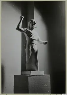 Limestone statue of a standing male figure with one arm raised, on a pedestal, from Kition