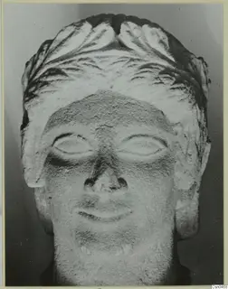 Frontal view of a limestone head from Mersinaki with carved hair and almond-shaped eyes