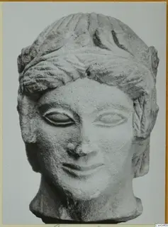 Limestone head from Mersinaki with wavy hair, almond-shaped eyes and a faint smile
