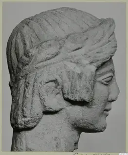 Limestone head in profile facing right, with a band across the hair and locks falling over the ear.